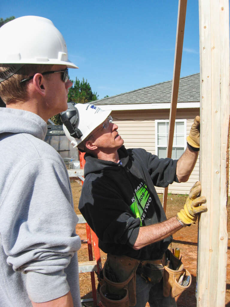 Ray Buyle shows student how to frame a house.