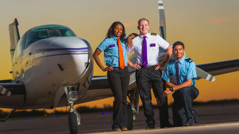 aviation students standing in front of an airplane