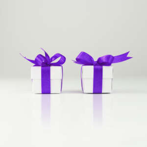 two white gift boxes with purple bows