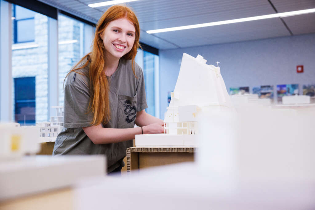 girl smiling in classroom working on project 