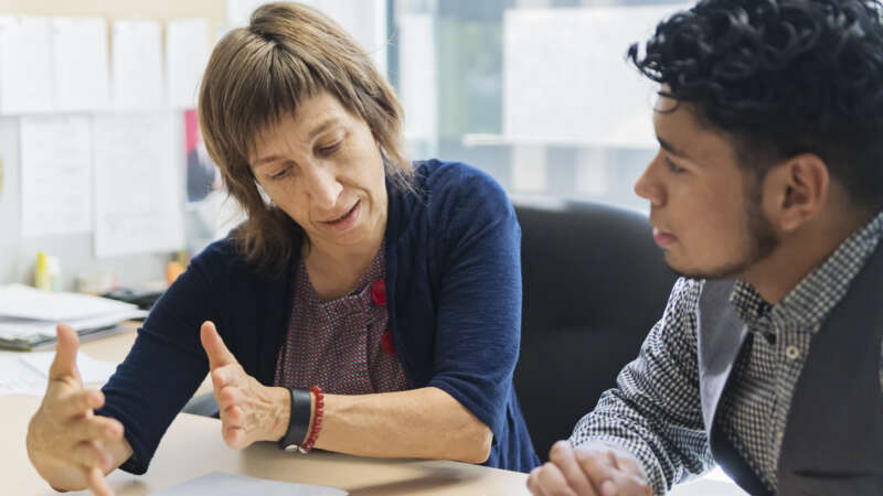 Advisor and student looking over document.