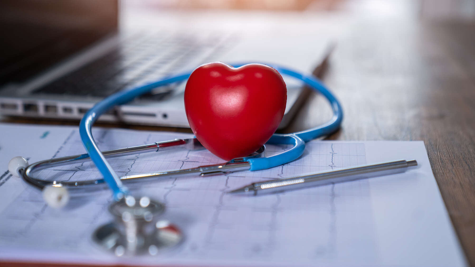 Heart on desk with stethoscope on laptop