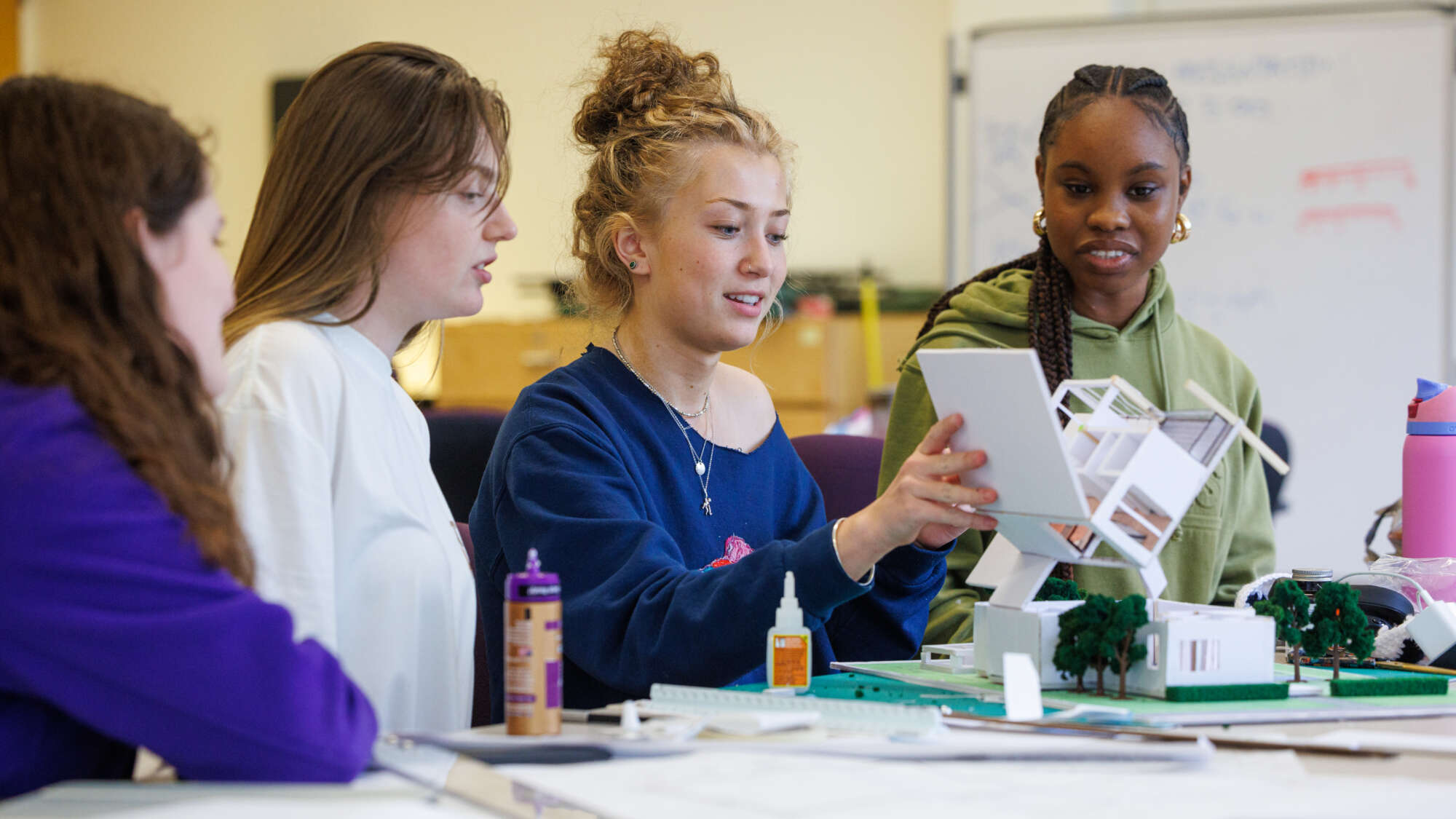 four female architecture students working on a model