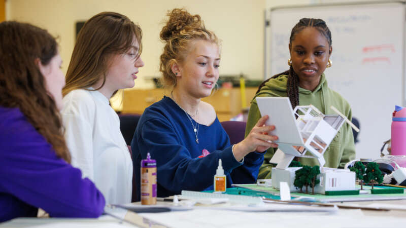 four female architecture students working on a model