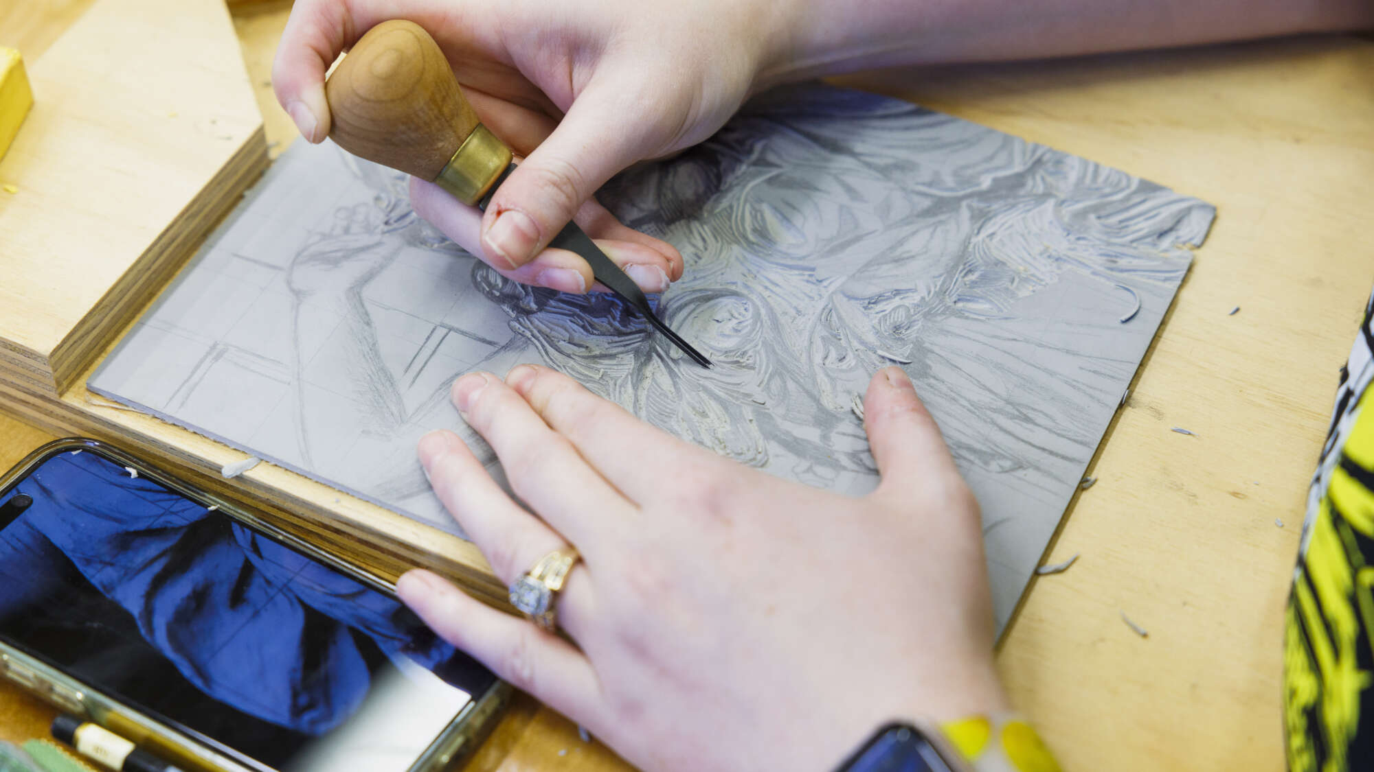 students hands carving a linoleum block print